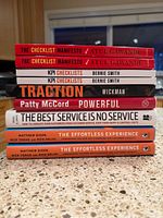 Stack of 11 business books showing spines for title and author identification