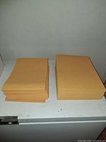 Two stacks of manila envelopes on shelf