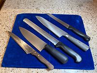 All five knives laid out on blue fabric