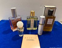 Group shot of six fragrance items displayed on blue surface