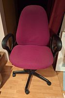 Front view showing magenta fabric seat, backrest, armrests, base and casters