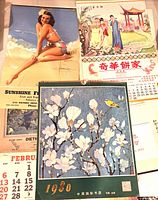 Group shot showing 1953 Sunshine Fruit Market pin-up, Chinese floral 1980 calendar, and Keefer Chinese Bakery scroll