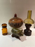 Group view of gourd, candle holder, amber jar, pottery pig