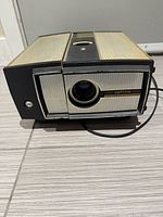 Front view of Optina projector showing lens and branding