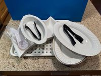 Group view of all white serveware, tray, tongs and scoops