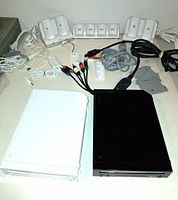 Lot overview with both Wii consoles, cables and charging docks visible