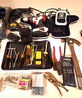 Overview of drill, charger, hand tools, tape measure, glue tool, fasteners