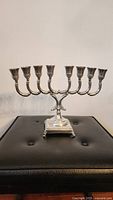Full view of sterling Hanukkah menorah on base