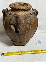 Front view of ceramic lime pot showing elephant head detail, rope on rim and base, full shape with measuring tape for scale