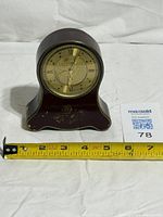 Front view showing entire Europa musical alarm clock with tape measure for scale