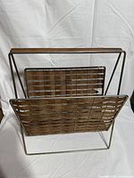 Front view of teak slat and brass frame magazine rack