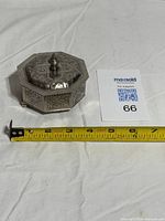 Box with lid closed next to ruler