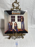 Front cover of Status Quo “On The Level” LP on stand