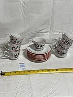 All cups and saucers stacked and displayed with measuring tape for scale