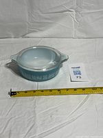 Top view of casserole with lid, measuring tape for scale