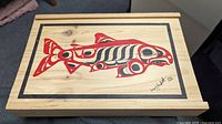 Top view showing painted salmon artwork and signature on cedar lid