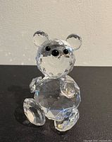 Front view of faceted crystal seated bear showing eyes, nose and overall form
