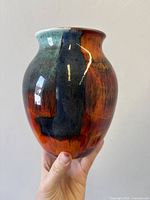 Front view of Poole England Volcano glaze vase held in hand