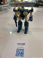 Front three-quarter view of the 1985 Robotech Alpha Veritech fighter toy standing on countertop with accessory rifle