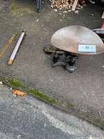 Overview showing scale with brass pan and adjacent wooden thermometer