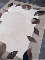 Full view of rectangular area rug with leaf border