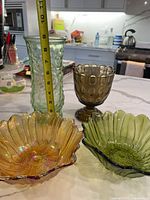 Group shot showing all four glass pieces with tape measure for scale