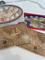 Overall view of three coin sets: two 1999 map folders, one 2000 red folder