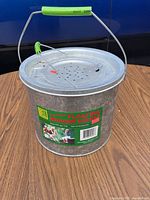 Top view of galvanized minnow bucket with handle and perforated lid