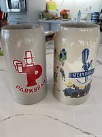 Front view of both 1 L steins showing Parkbrau and Steam Whistle logos
