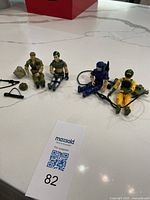 All four G.I. Joe figures seated with accessories and mountain-climber gear visible