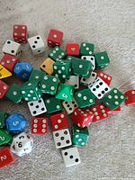 Pile of multi-colored six-sided and polyhedral dice on cloth surface