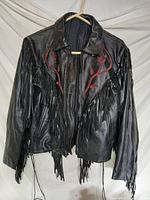 Front view of black leather jacket with fringe and red appliqué