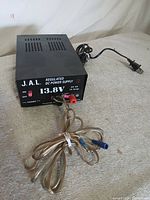 Front and top of J.A.L. BK-PS1 power supply with accessory cable