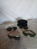 Group shot of four pairs of sunglasses arranged on fabric backdrop