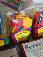 Three jars of Ideal Standard Plastic Pattern Blocks, multicolored shapes visible