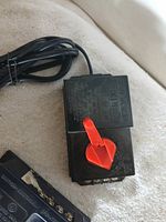 Black transformer with red lever throttle, cord, terminals visible