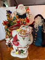 Front view of Fitz and Floyd ceramic Santa on donkey with other Santa figures in background