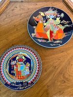 Front view of both Wiinblad plates showing artwork and signatures