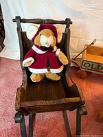 Wooden sleigh with plush mouse seated inside