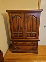 Armoire closed showing paneled doors and exterior drawers