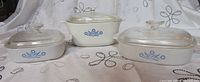 Front view of three CorningWare Blue Cornflower casserole dishes with lids