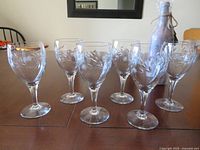 Front view of six etched wine glasses on table