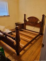 Full view of assembled queen bed frame showing headboard, footboard, side rails, and slats