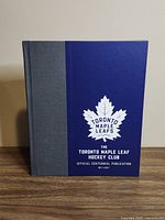 Front cover showing title, centennial dates, Maple Leafs crest