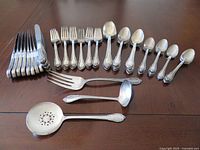 Overall set laid out showing knives, forks, spoons and three serving utensils