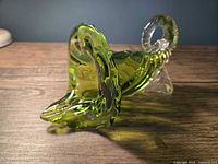 Side view showing electric lime green cornucopia form with clear twisted handle and foot