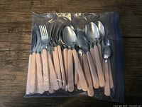 Zip bag of pink-handled stainless flatware