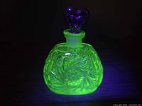 Bottle glowing vivid green under UV light, front view