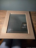 Front view of rectangular mirror with faux wood grain frame