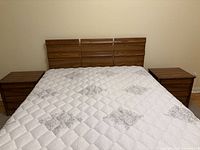 Bed frame, headboard, mattress, both nightstands visible